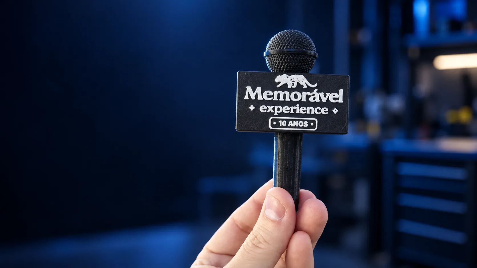 Microfone personalizado do evento Memorável Experience sobre a mão, com tratamento visual
